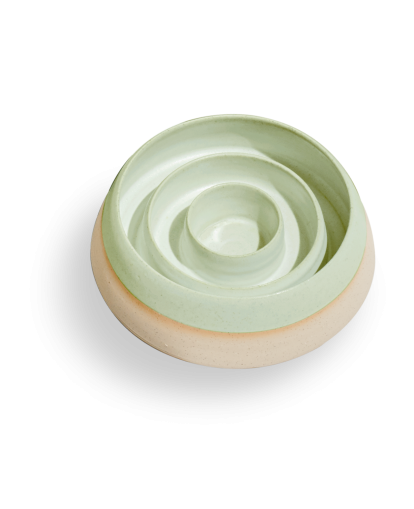 Een groene kom met een cirkelvormig ontwerp, perfect om eten op te serveren of uit te stallen.